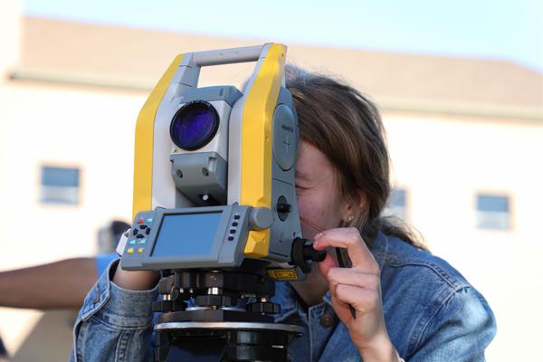 A female student operating surveying equipment